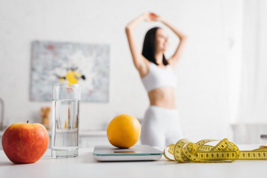 Gezonde levensstijl concept met vers fruit, een glas water, een keukenweegschaal en een meetlint in een lichte, minimalistische omgeving.
