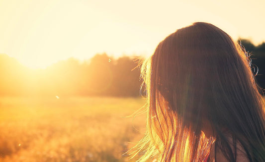 Vrouw in zonlicht als symbool voor natuurlijke vitamine D aanmaak