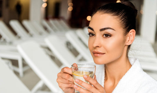 Vrouw drinkt rustgevende kruidenthee in wellnessomgeving