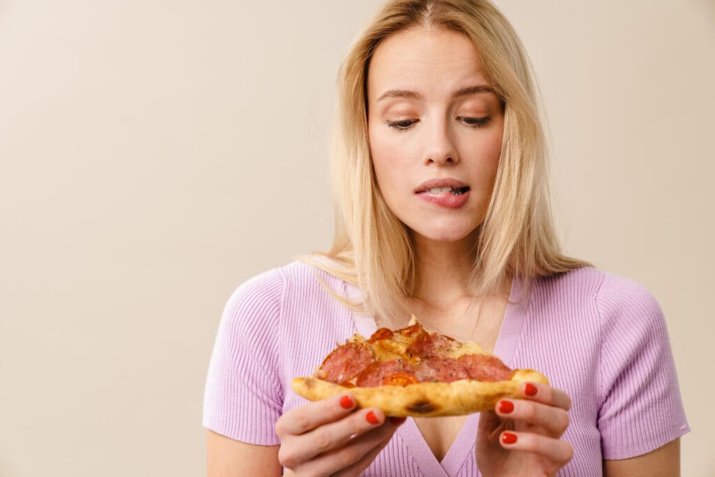 Vrouw met ongezonde ultrabewerkte pizza