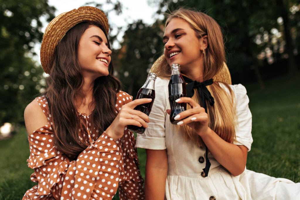 Twee jonge vrouwen die cola zero drinken als gezonde optie