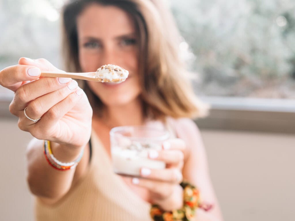 Vrouw eet yoghurt met lijnzaad of chiazaad