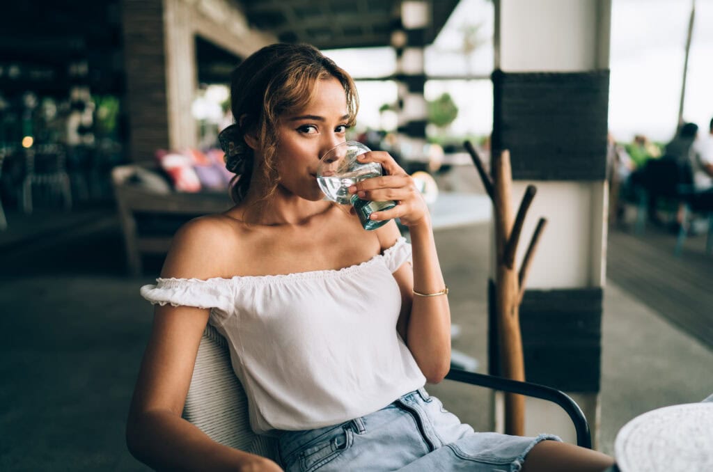 Jonge Vrouw drinkt water wil tips om te vermageren